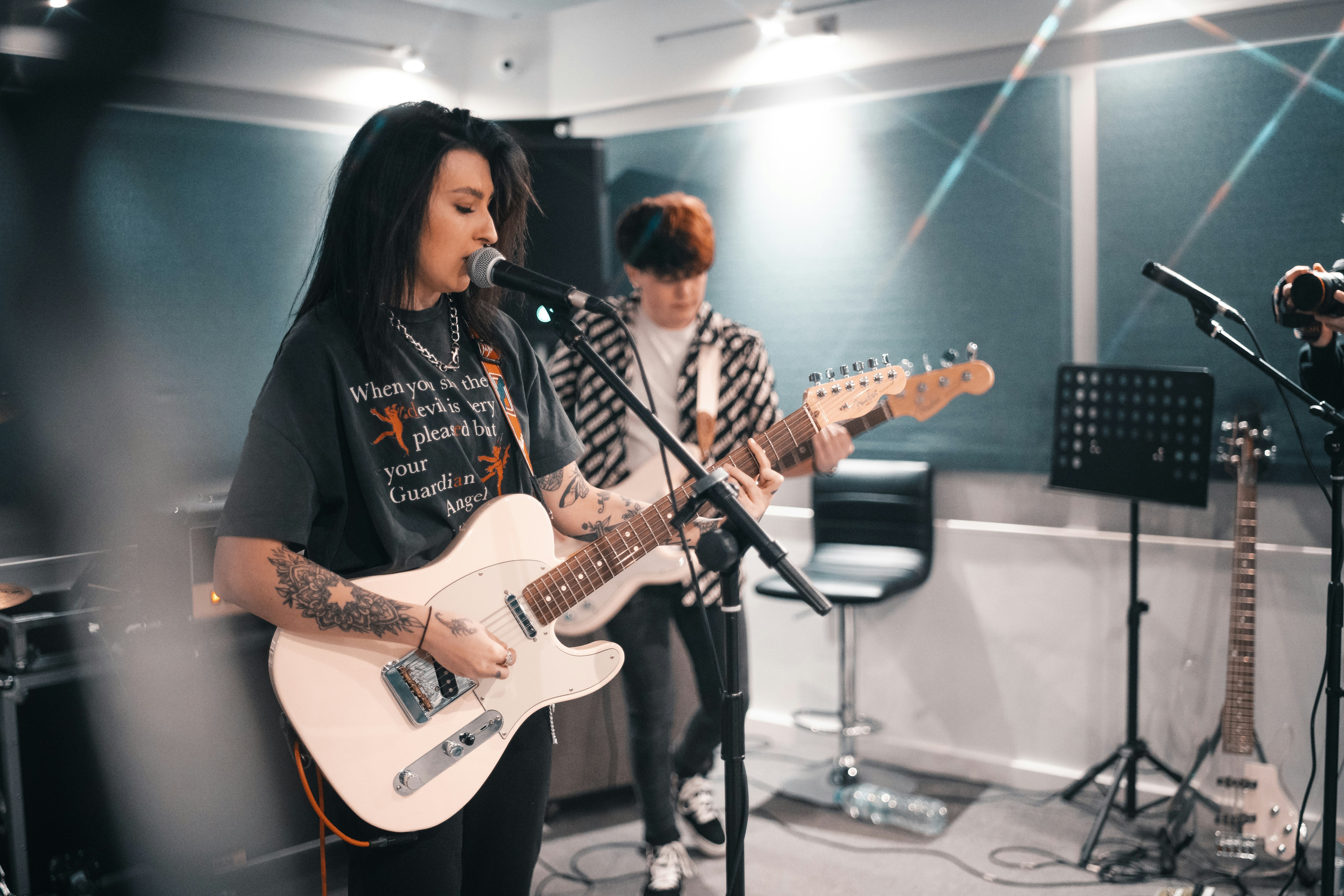 man in black shirt playing white electric guitar